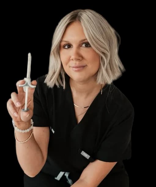 Claire, RN, in black scrubs, smiling and holding a filler syringe