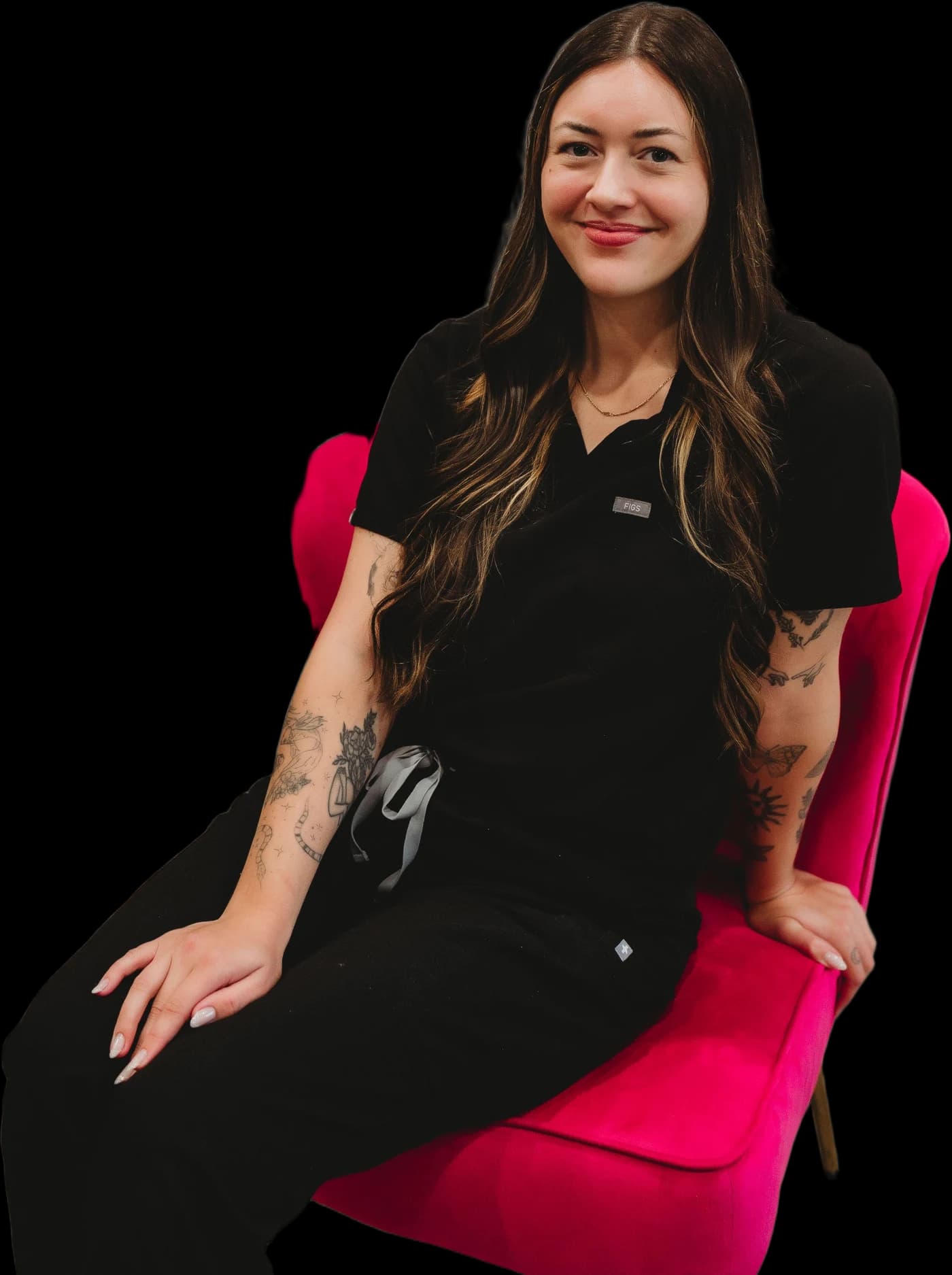 Maggie, esthetician, sitting on the hot pink velvet chair, smiling
