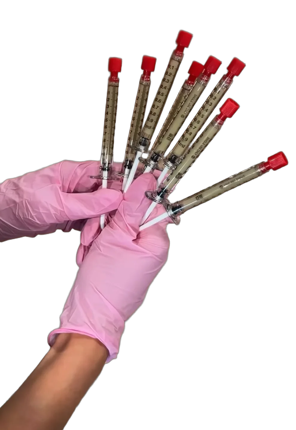 A nurse's pink gloved hand fanning out filled syringes
